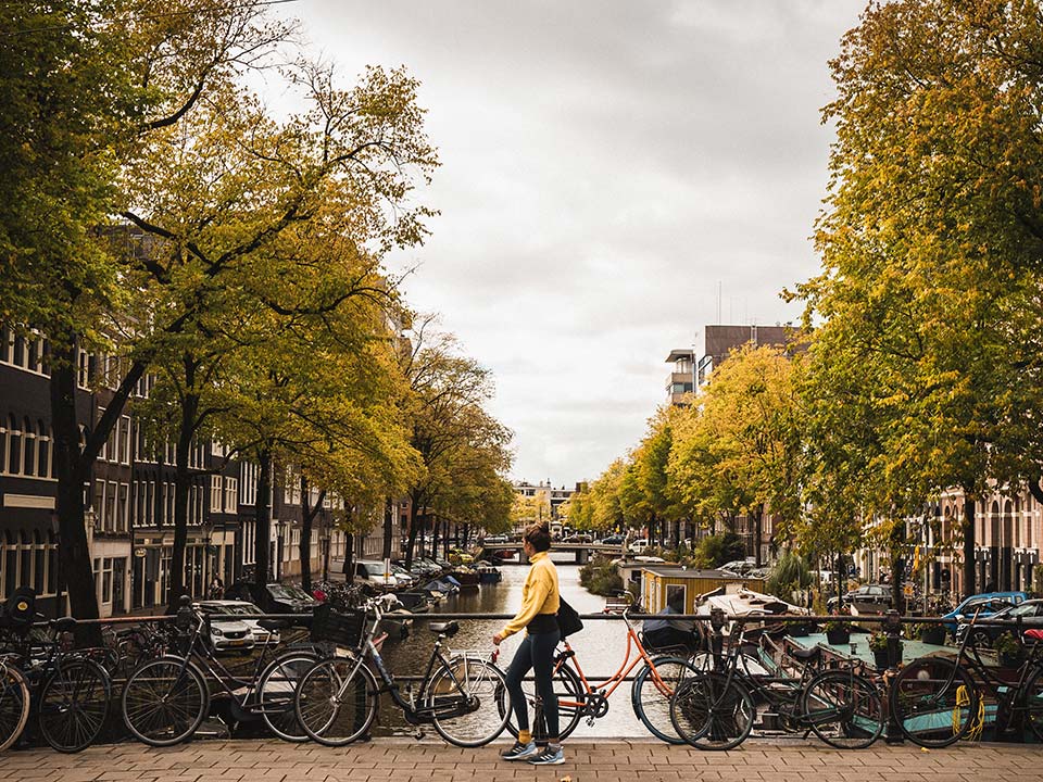 En person går över en bro i Amsterdam